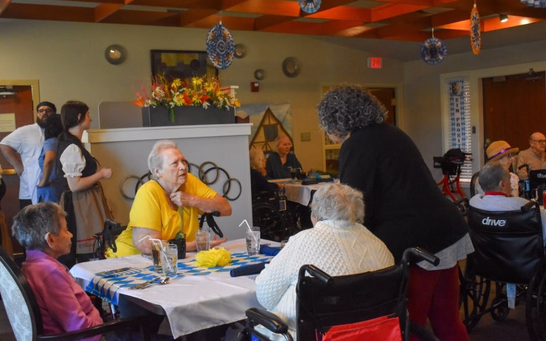 A server brings a plated meal to a resident at the Heritage dining room at Willow Brook Home, where attentive hospitality and varied menus support daily life for assisted living residents in Columbus, Ohio.
